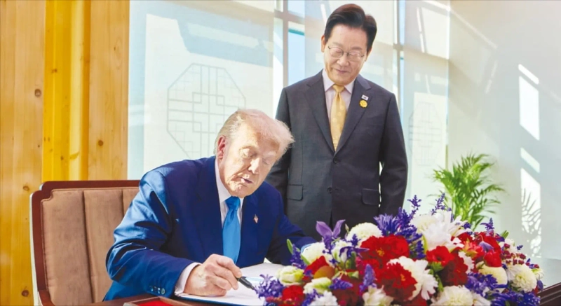 < 경주박물관서 방명록 작성하는 트럼프 > 이재명 대통령이 29일 한·미 정상회담이 열린 국립경주박물관에서 도널드 트럼프 미국 대통령이 방명록을 작성하는 모습을 보고 있다. 대통령실 제공