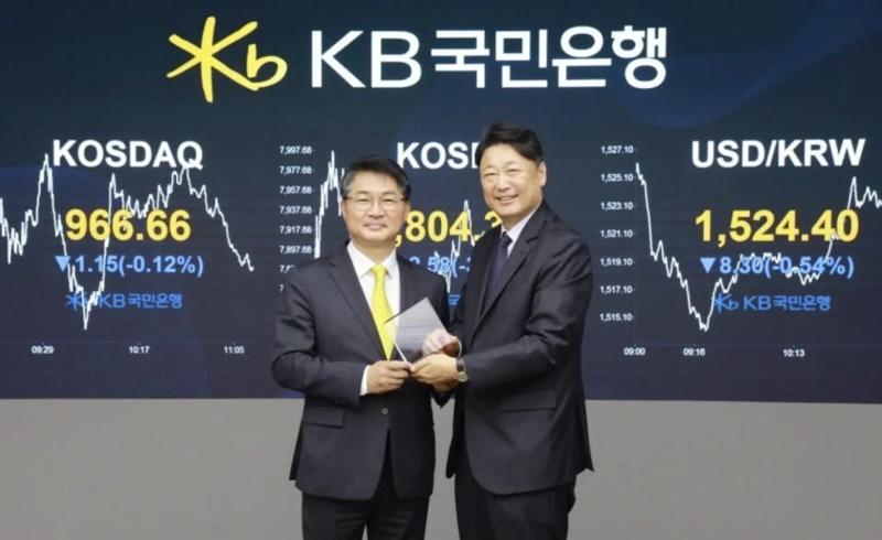 Lee Seong-hee, executive vice president of KB Kookmin Bank’s Capital Markets Group, left, and Lee Sang-ho, chief representative of HSBC’s Seoul branch, pose for a photograph after a signing ceremony for the digital bond issuance at KB Kookmin Bank’s dealing room in Seoul’s Yeouido district on June 10. Photo: KB Kookmin Bank